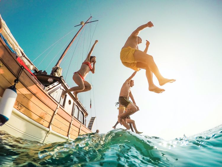 People jumping off of a boat for fun